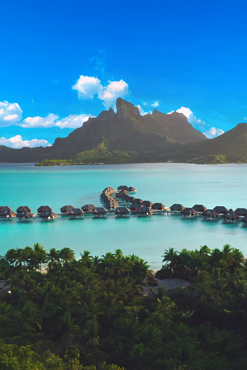 Overwater bungalows and turquoise lagoon overlooking Mount Otemanu in Bora Bora.